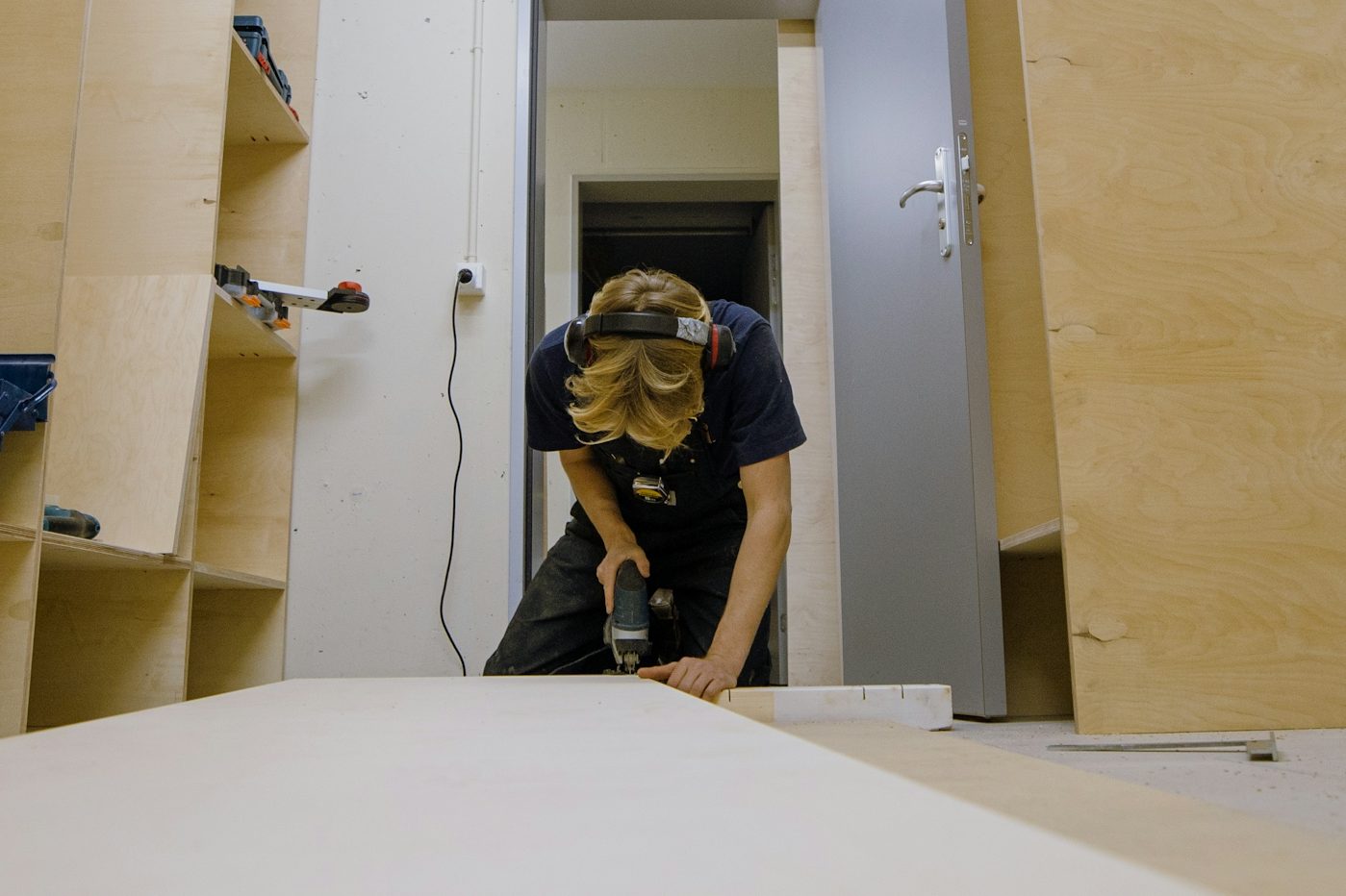 Reparaturen Handwerker sägt mit der Handkreissäge eine Platte in der Werkstatt